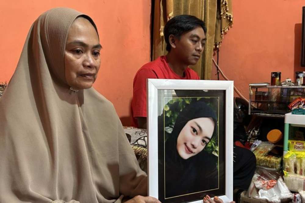 Siti Mardiyah (kiri) didampingi anak pertamanya Andik Kurniawan, memegang foto Mitha Maulidia yang meninggal dunia dalam peristiwa Tragedi Kanjuruhan. - Antara