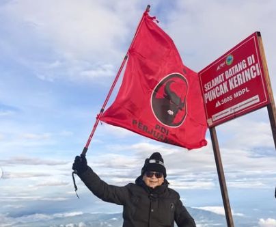 Hasto Kristiyanto mengibarkan bendera PDIP di puncak Gunung Kerinci. (Foto: instagram.com/@sekjenpdiperjuangan)